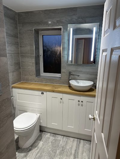 Finished bathroom by Andrade Renovations with grey tiling, a wood vanity worktop and a vessel basin